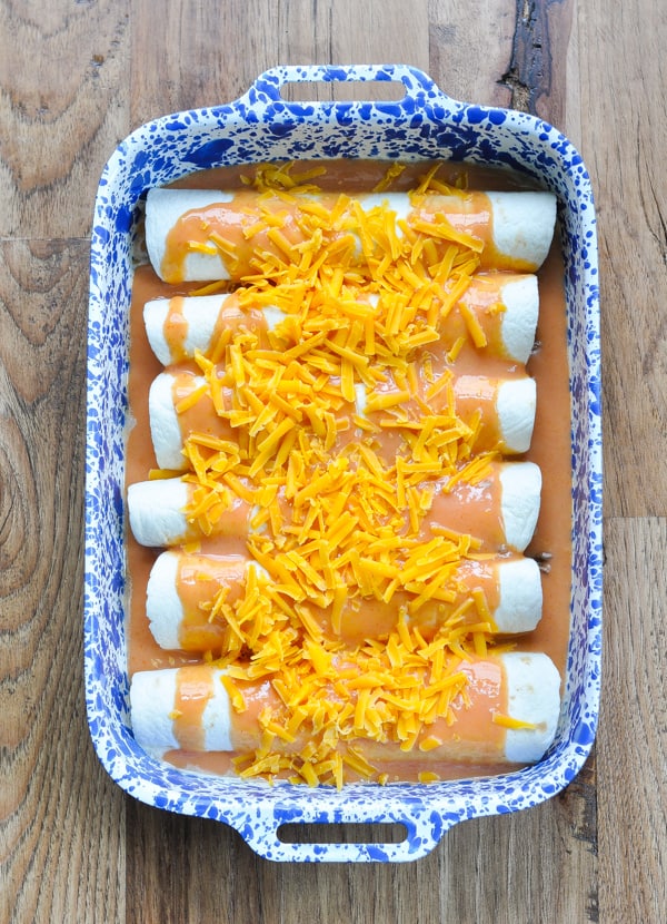 Enchiladas topped with cheese before going in the oven