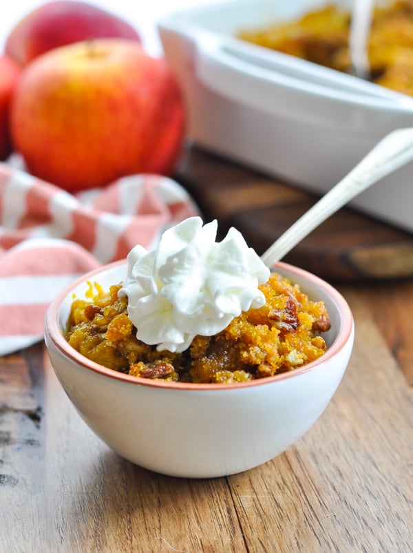 Bowl of southern sweet potato casserole with pecans and whipped topping