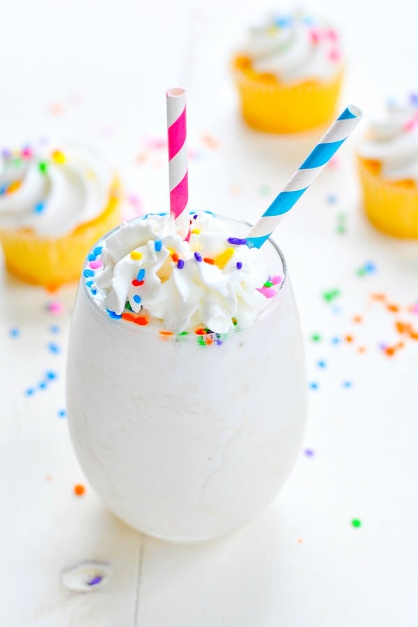 Birthday cake flavored healthy smoothie recipe in a glass with whipped cream and sprinkles