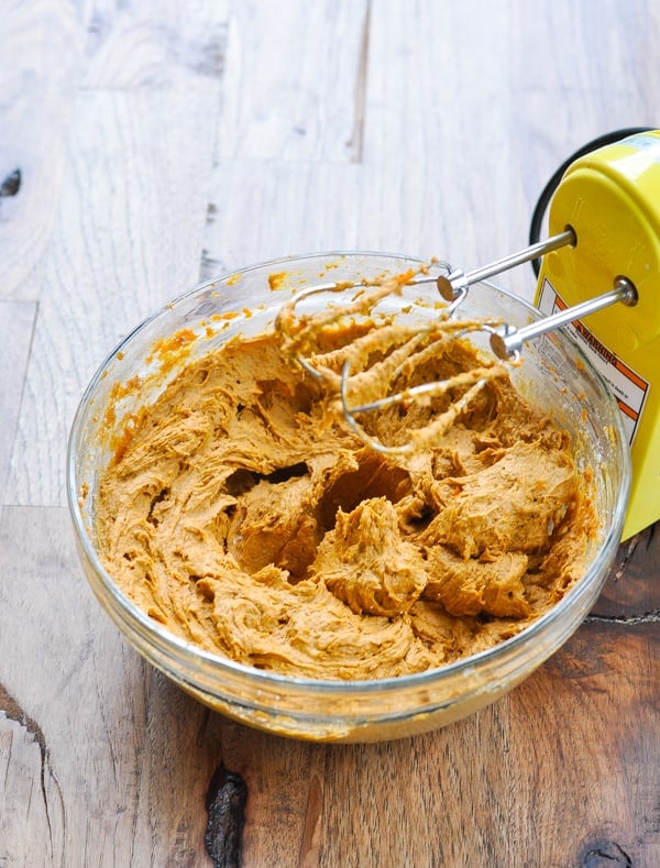 Pumpkin muffin batter in glass bowl with electric mixer