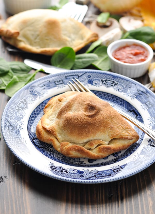 Golden brown baked calzone on a plate