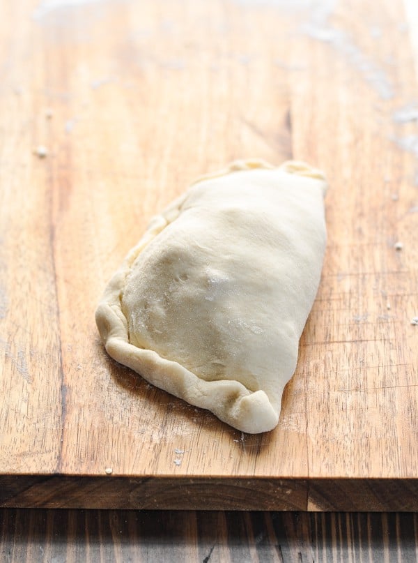 Folded calzone on cutting board before baking