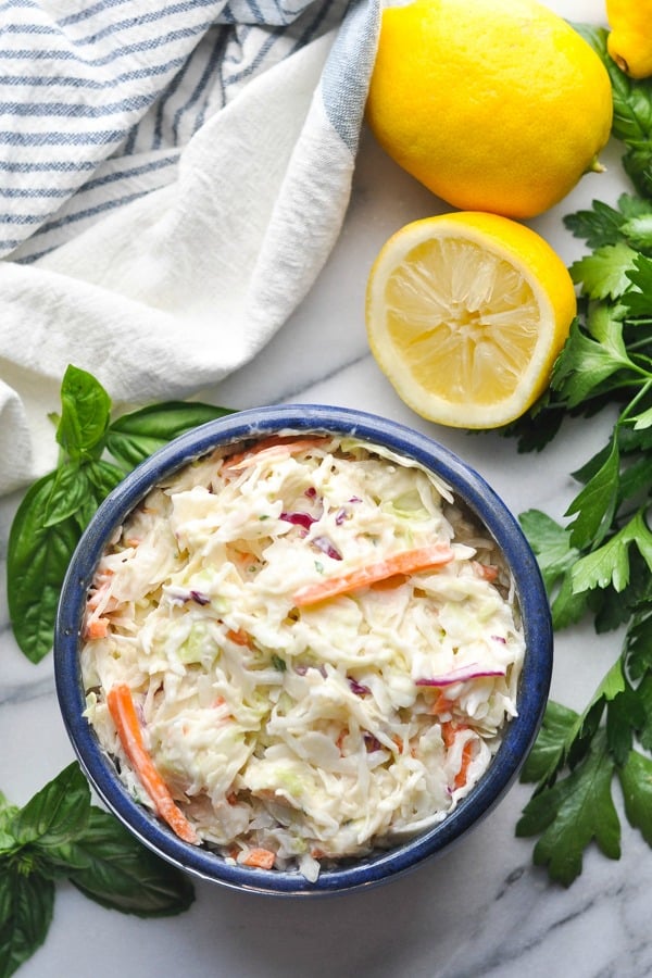 Overhead shot of coleslaw dressing tossed with shredded cabbage and carrots