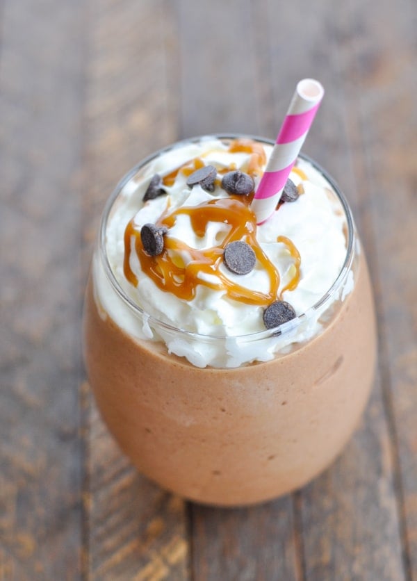 Close up image of salted caramel mocha protein shake with pink and white striped straw