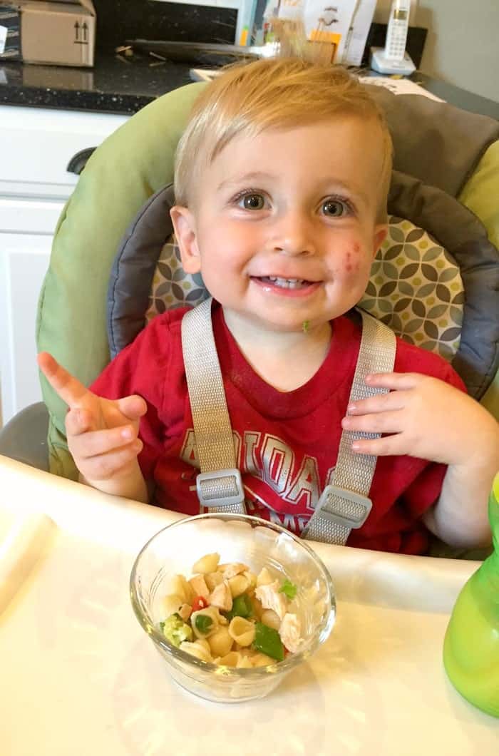 A boy Eating some sesame chicken pasta