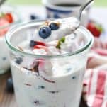 Spoon in a jar full of overnight oats with berries and almonds