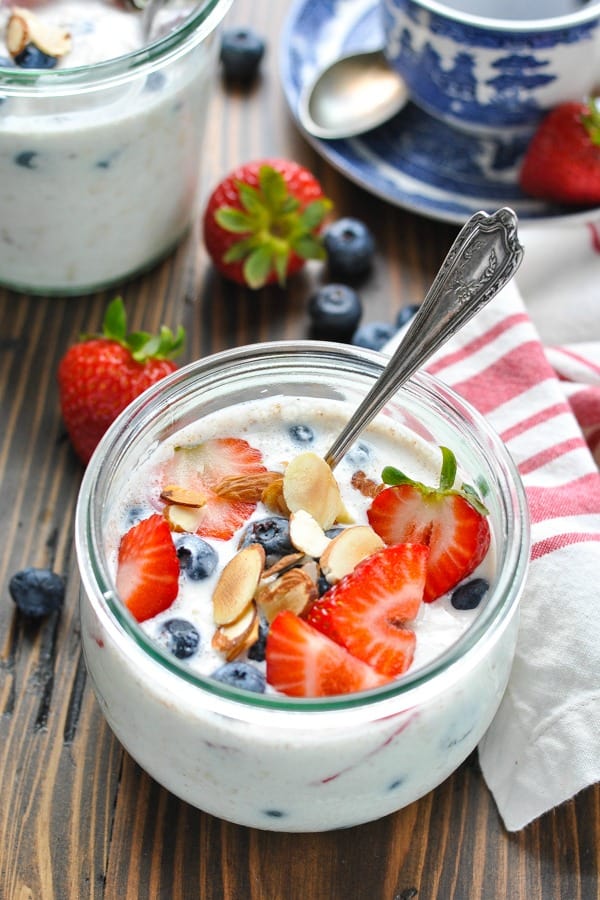 Fresh strawberries and blueberries on top of a bowl of overnight oatmeal