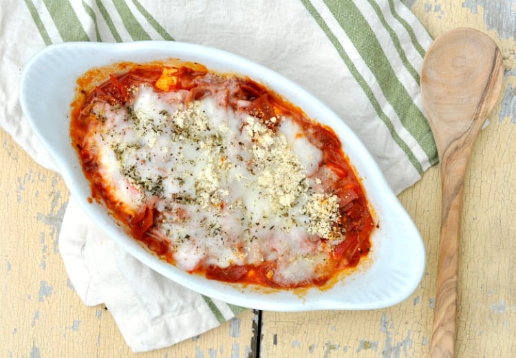 A microwave pizza dip in a white dish with a wooden spoon