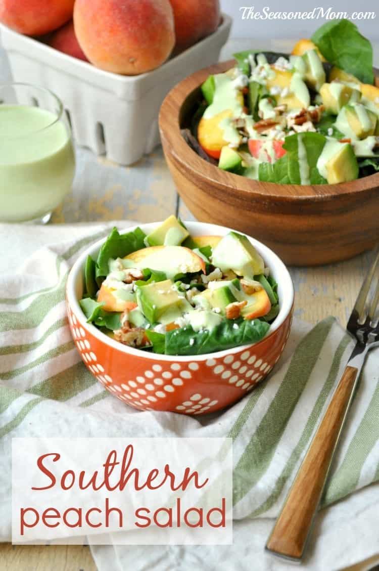A peach salad with avocado and green dressing in a bowl