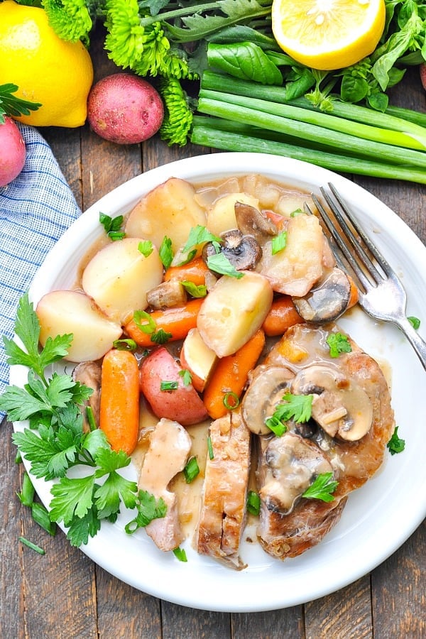 Slow cooker pork chops on a plate with vegetables