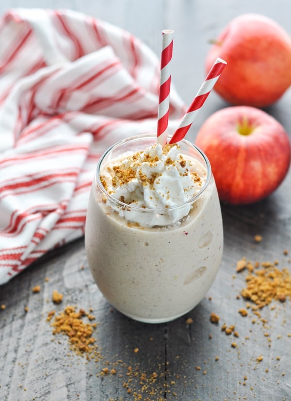 Glass of healthy apple pie smoothie with red and white striped straws