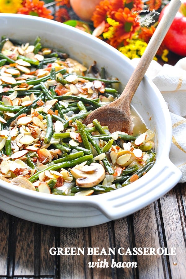 Healthy and fresh green bean casserole with bacon in a white baking dish with text overlay