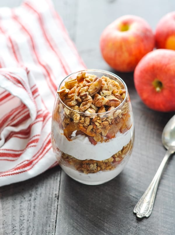 Healthy Greek yogurt parfait with layers of apple and granola and pecans