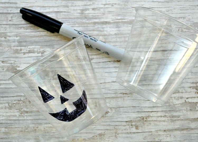 Empty plastic cups with a halloween jack o lantern drawn on them