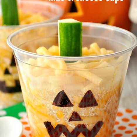 A close up of a mac and cheese cup in a halloween pumpkin cup