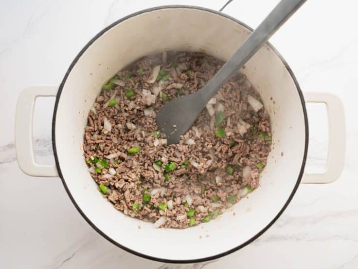 Sauteing vegetables with ground beef for chili.