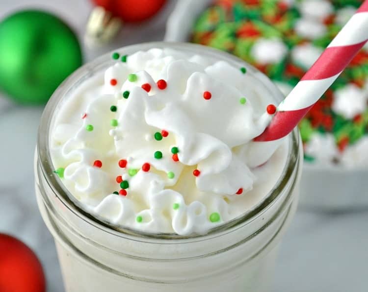 A close up of a frosted sugar cookie protein shake topped with cream and sprinkles