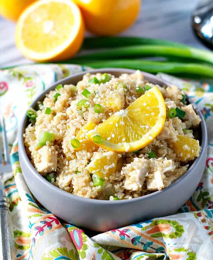 Sesame chicken quinoa in a bowl topped with fresh oranges