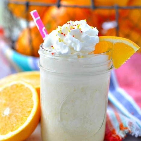 A close up of an orange smoothie in a mason jar