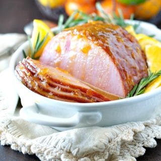 Glazed baked ham in a dish with rosemary