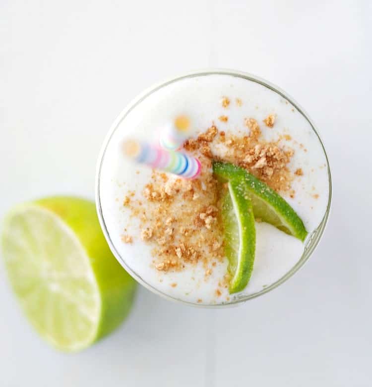 An overhead shot of an easy key lime pie smoothie topped with lime slices and crumbs