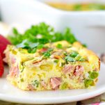 Baked omelet with spring vegetables on a white plate