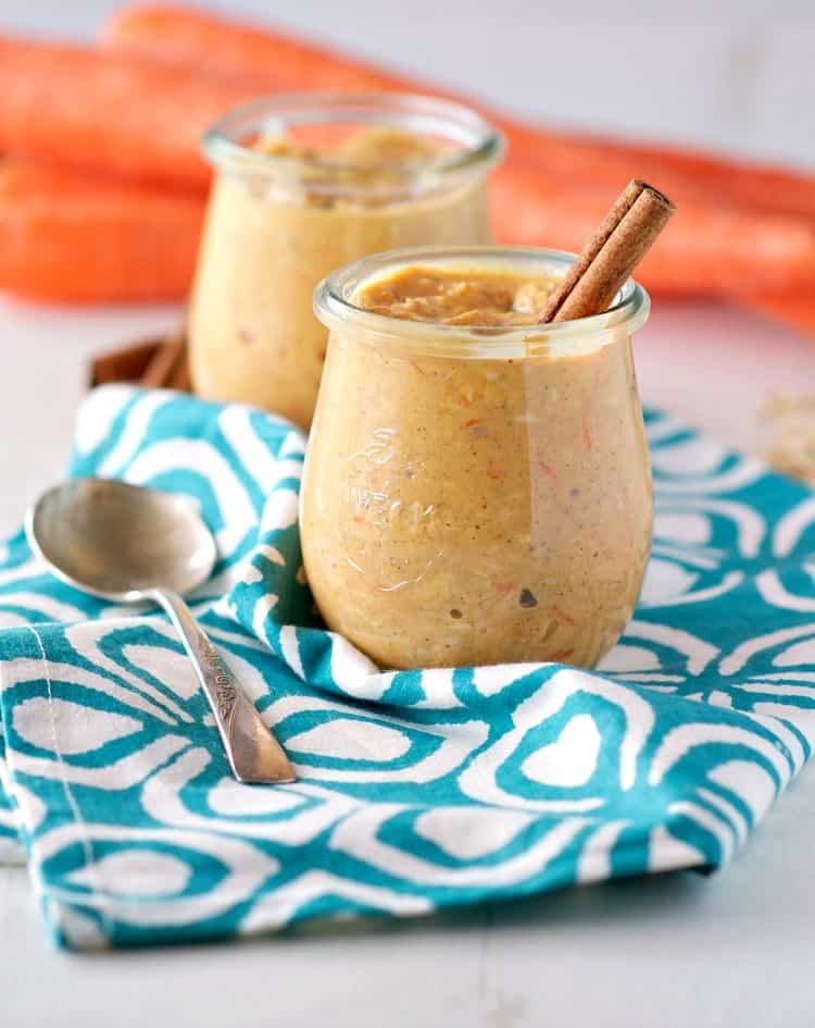 A jar filled with carrot cake overnight oats and topped with a cinnamon stick