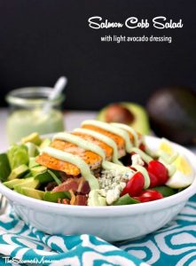 A salmon cobb salad with avocado dressing in a bowl