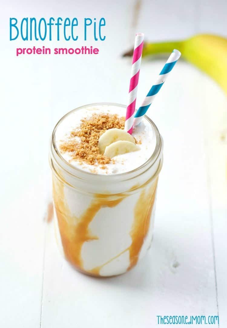 A jar filled with a banoffee pie smoothie topped with slices of banana and two straws