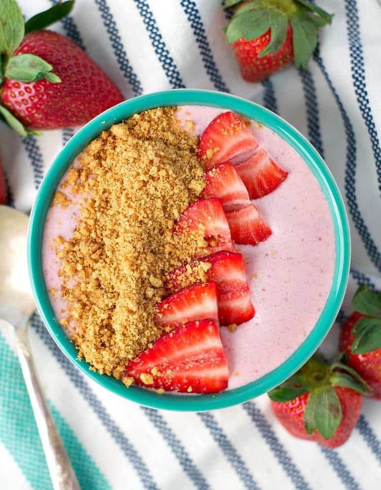 An overhead shot of a strawberry cheesecake smoothie bowl