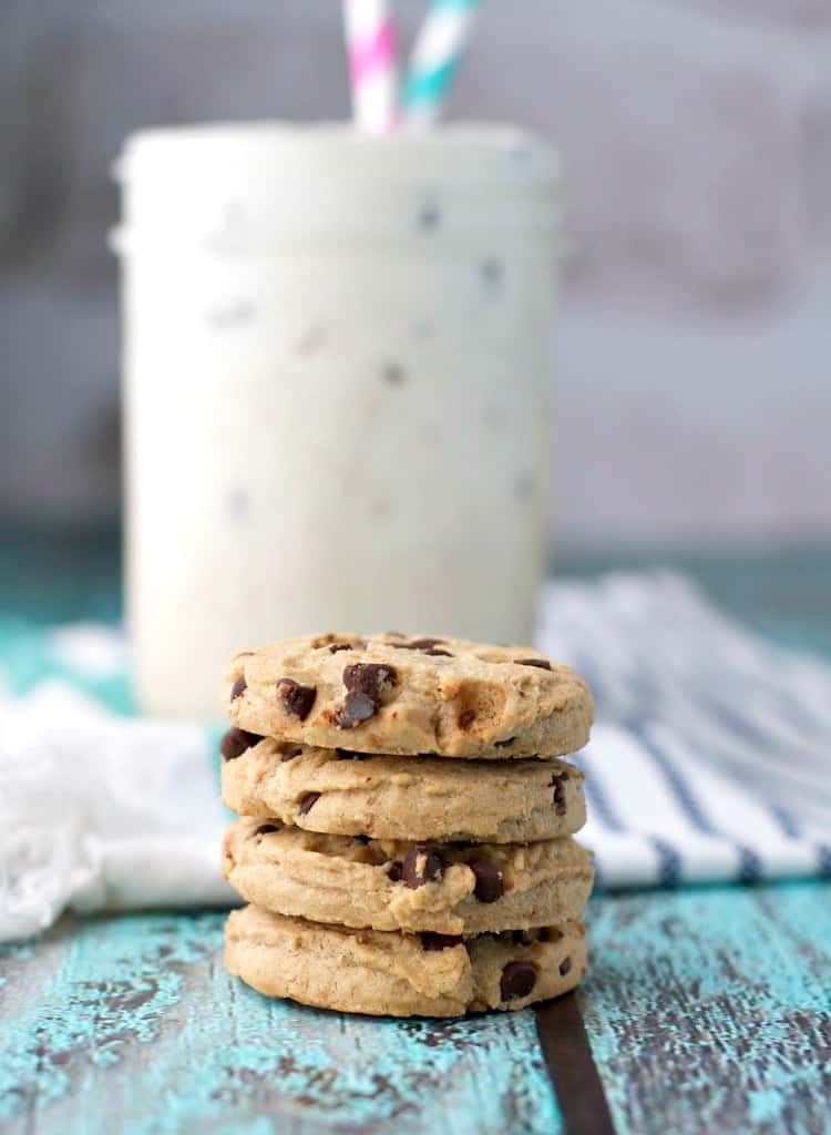 A close up of a stack of chocolate chip cookies and a cookie dough smoothie in the background