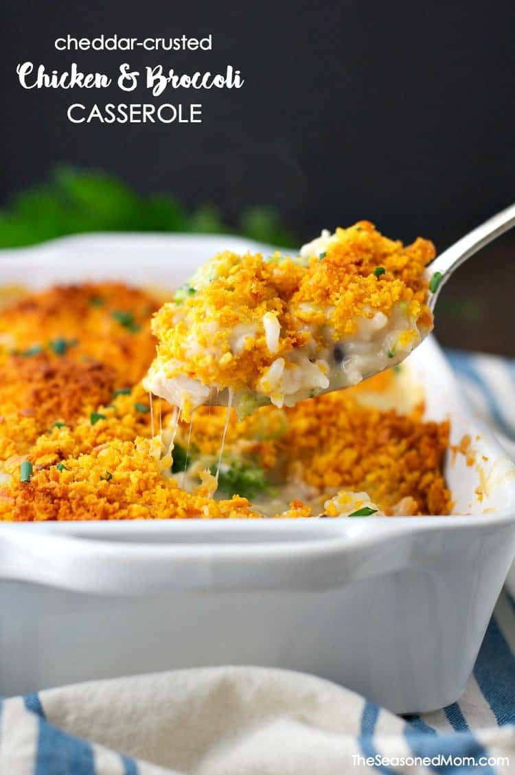 Cheddar crusted chicken and broccoli casserole in a white dish with a serving spoon