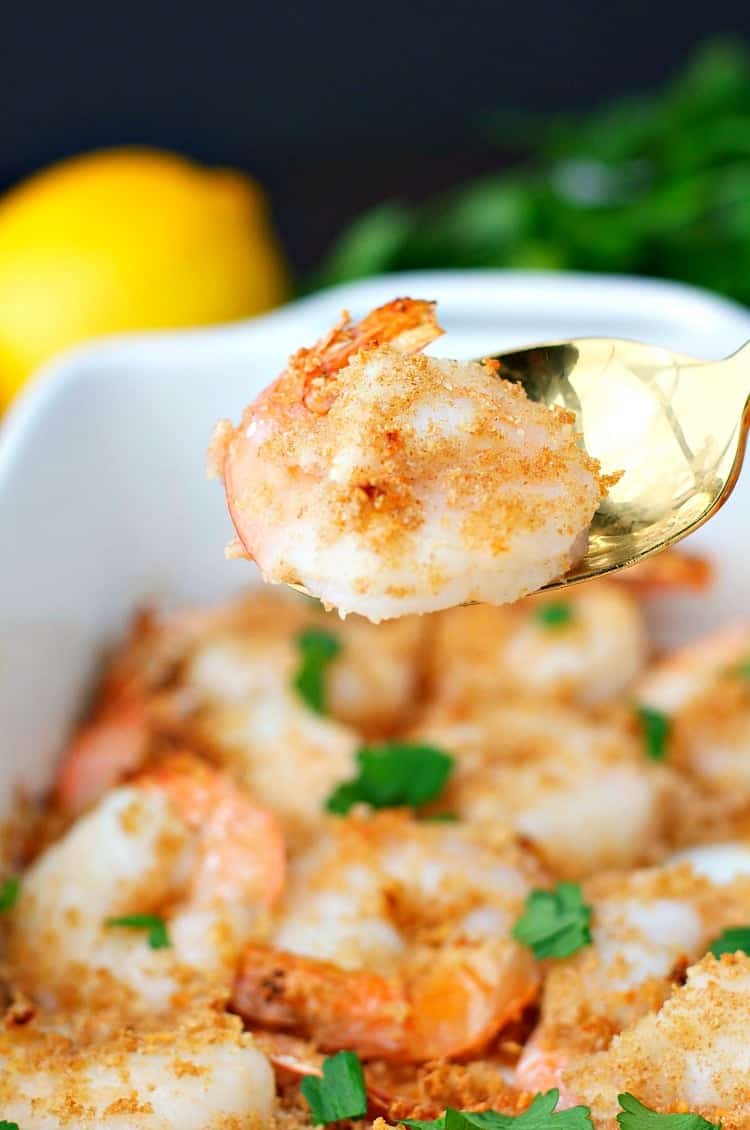 A close up of garlic butter shrimp on a spoon