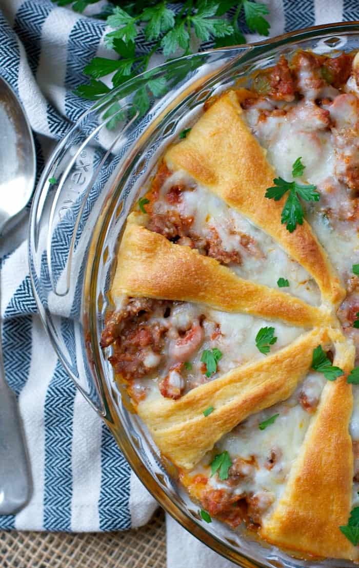 An overhead shot of a Sausage and Pepperoni Crescent Roll Pizza in a glass dish