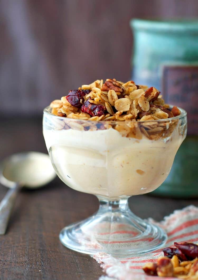 A photo of pumpkin spice granola in a glass bowl with milk