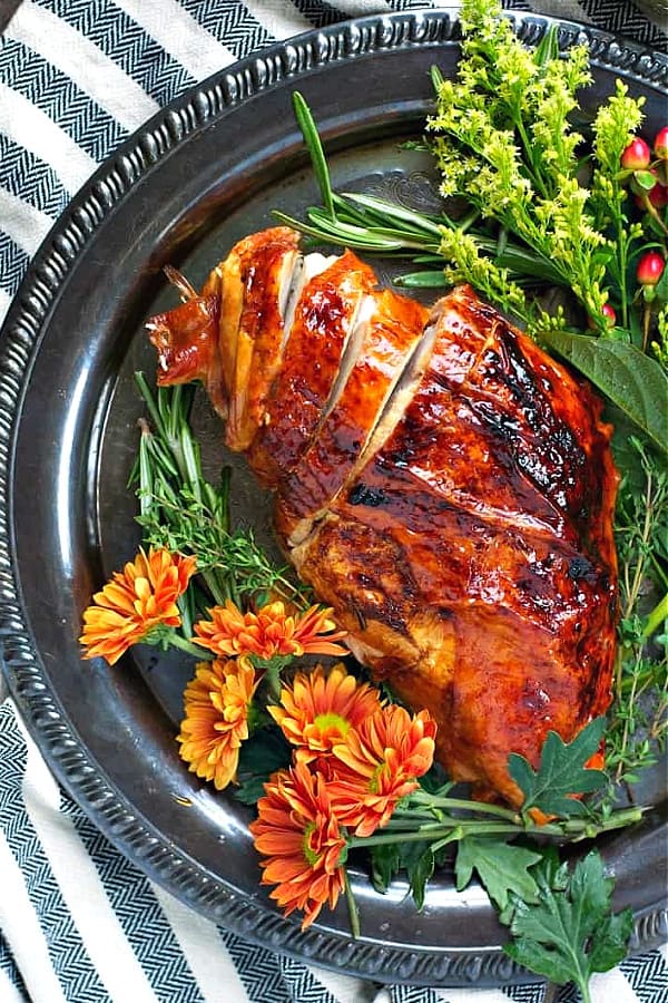Sliced maple glazed roasted turkey breast on a silver platter