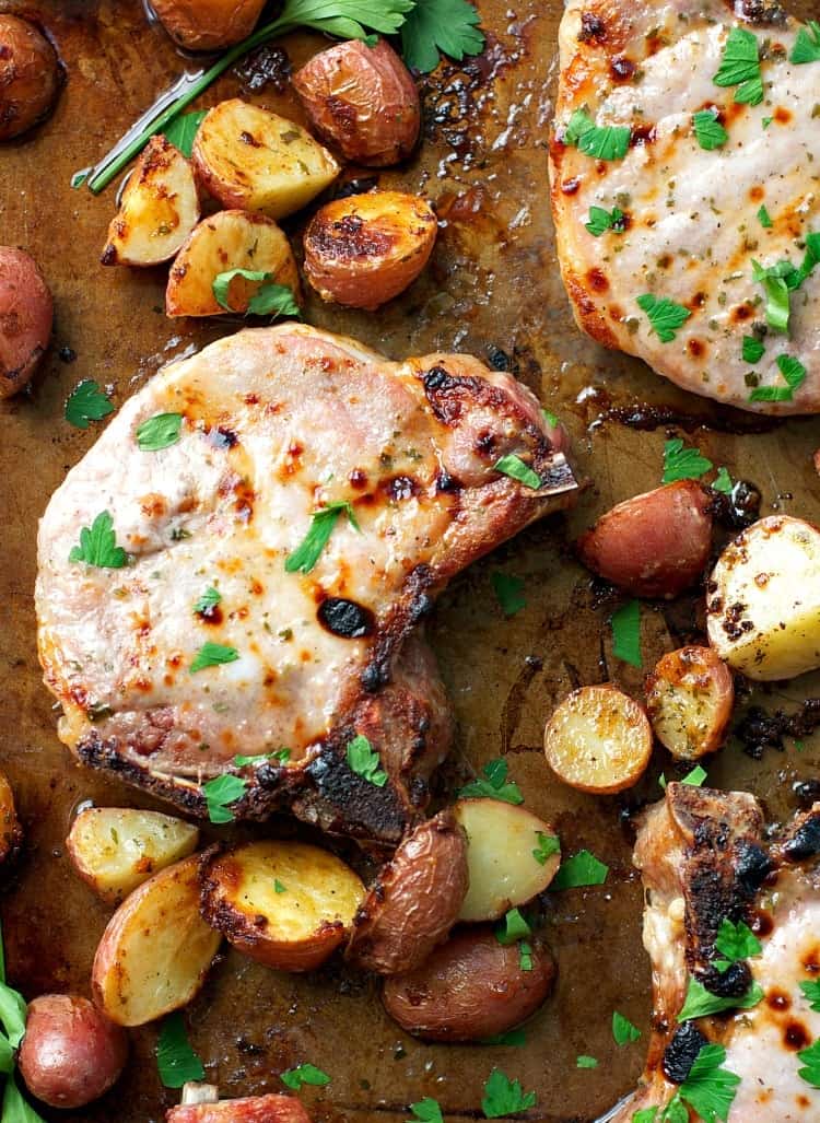An overhead shot of ranch pork chops in a pan with crispy potatoes
