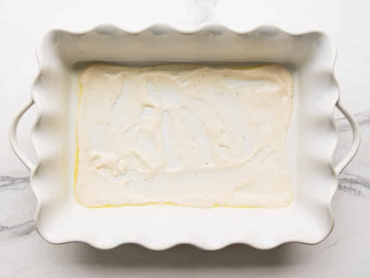 A thin layer of Alfredo on the bottom of a baking dish.