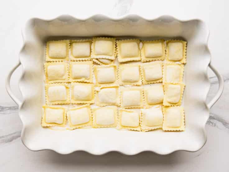 A layer of frozen ravioli in the bottom of the baking dish.