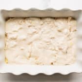 Adding a layer of Alfredo on top of the chicken and ravioli.