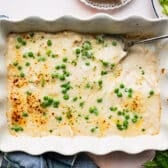 Horizontal overhead shot of chicken ravioli alfredo in a white baking dish.