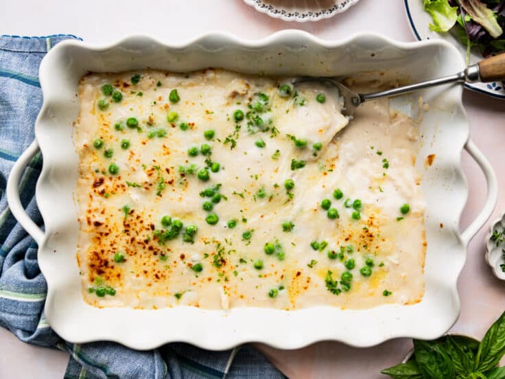 Horizontal overhead shot of chicken ravioli alfredo in a white baking dish.