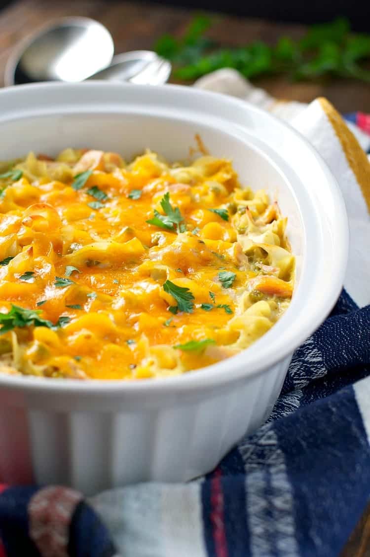 Tuna noodle casserole in a white dish topped with cheese
