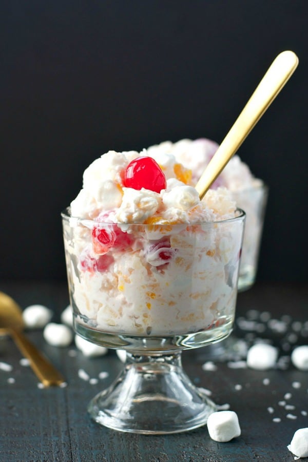 Ambrosia salad recipe in a glass dish with cherry on top