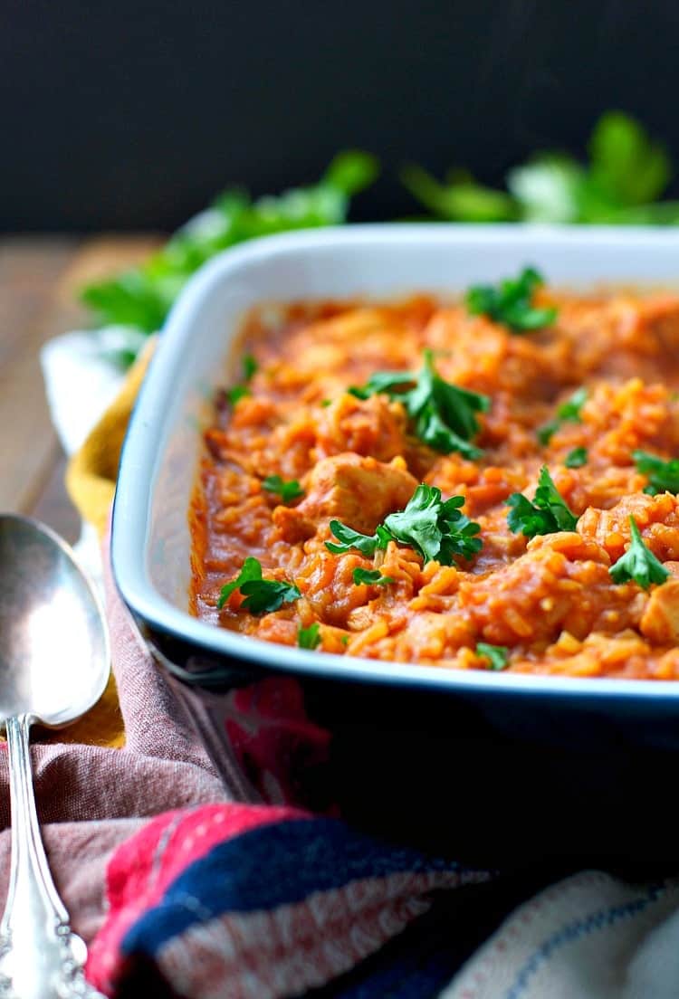 A close up of butter chicken and rice in a baking dish