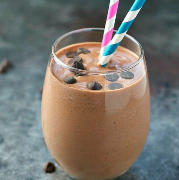 Glass of chunky monkey chocolate protein smoothie with chocolate chips on top