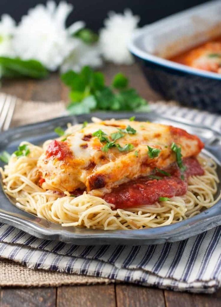 Healthy chicken parmesan on top of spaghetti on a plate