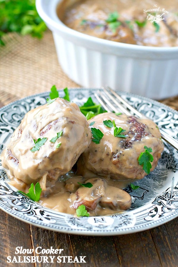 Slow Cooker Salisbury Steak with mushroom gravy on a black and white plate