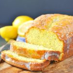 Loaf of lemon poppy seed bread sliced on a cutting board