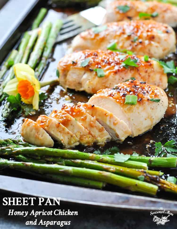 Honey Apricot chicken on a baking tray with asparagus